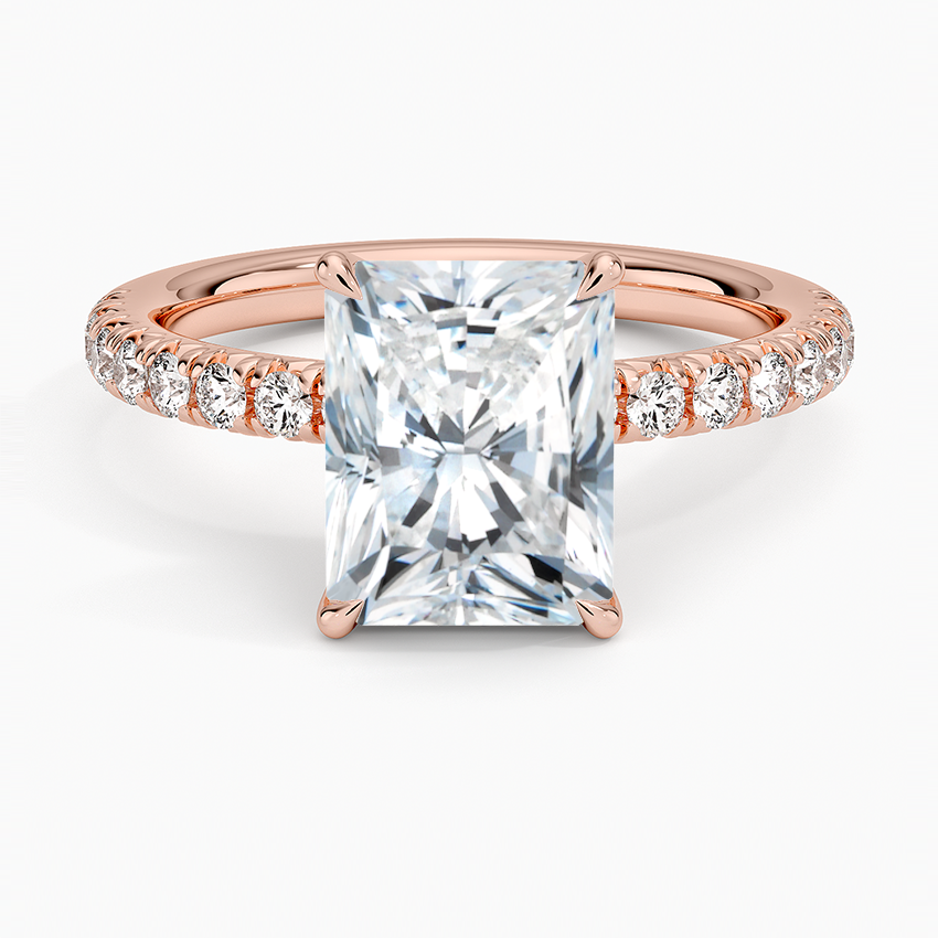 Rose gold ring with a large diamond and smaller diamonds on the band against a white background