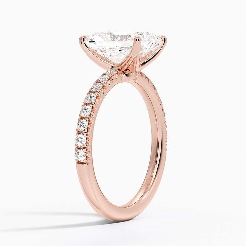 Rose gold ring with a large diamond and smaller diamonds on the band against a white background