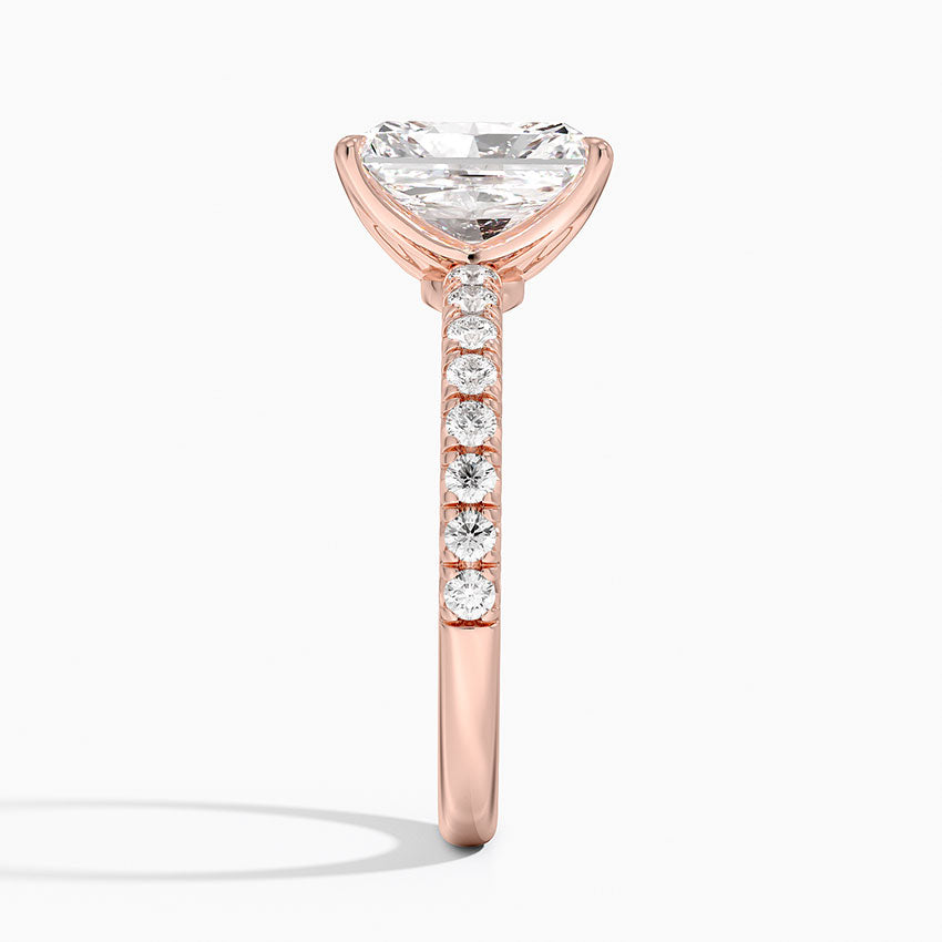 Rose gold ring with a large diamond and smaller diamonds on the band against a white background
