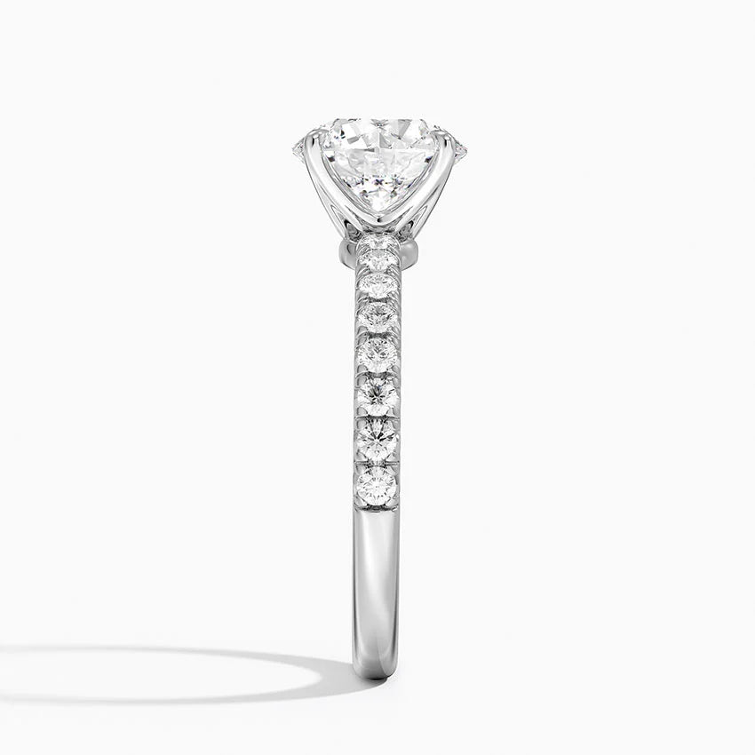 Diamond ring with a central stone and smaller stones on the band against a white background
