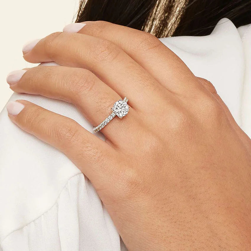 Close-up of a hand wearing a diamond ring with a white background